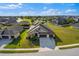 Expansive aerial view of a well-maintained home with a three-car garage and lush green lawn at 13065 Bliss Loop, Bradenton, FL 34211