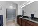 Bathroom with double vanity, wood cabinets, black granite counters, tub and shower combo at 13065 Bliss Loop, Bradenton, FL 34211