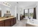 Bright bathroom featuring double vanities, granite countertops, soaking tub and tile floors at 13065 Bliss Loop, Bradenton, FL 34211