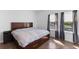 Bedroom featuring hardwood floors, a large bed, bedside table, and large windows at 13065 Bliss Loop, Bradenton, FL 34211
