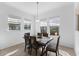 Cozy dining area with a wood table, seating for six, and bright natural light from three large windows at 13065 Bliss Loop, Bradenton, FL 34211