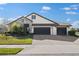 Charming single-Gathering home features stone accents, manicured lawn and a three-car garage on a sunny day at 13065 Bliss Loop, Bradenton, FL 34211