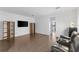 Hardwood floors, media center, black leather love seat and light colored walls in the living room at 13065 Bliss Loop, Bradenton, FL 34211