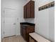 Mudroom with tiled floors, dark cabinets, and a bench for shoes and storage at 13065 Bliss Loop, Bradenton, FL 34211