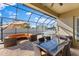 Enclosed patio featuring sleek seating arrangement, dining table, and a hot tub for backyard relaxation at 13065 Bliss Loop, Bradenton, FL 34211