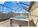 Enclosed patio featuring a relaxing hot tub and lounge chairs perfect for outdoor leisure at 13065 Bliss Loop, Bradenton, FL 34211