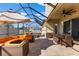 Enclosed patio featuring sleek seating arrangement, dining table, and a hot tub for backyard relaxation at 13065 Bliss Loop, Bradenton, FL 34211