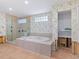 Spacious bathroom with tiled platform tub, glass enclosed shower, and walk-in closet at 1374 Moonmist Dr # B1, Sarasota, FL 34242