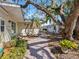 Inviting front yard featuring a brick walkway, lush landscaping, and mature trees at 1374 Moonmist Dr # B1, Sarasota, FL 34242