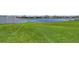 Lush green lawn provides a serene backyard, complete with a fence and a view of the lake at 15008 Trinity Fall Way, Bradenton, FL 34212