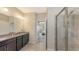 A well-lit bathroom leads to a bedroom and features a shower and double vanity at 15008 Trinity Fall Way, Bradenton, FL 34212