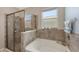 Bathroom featuring a separate shower and tub with tile surround at 15008 Trinity Fall Way, Bradenton, FL 34212