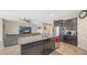 Open-concept kitchen with granite island and dark wood cabinets flows into living area at 15008 Trinity Fall Way, Bradenton, FL 34212