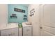 Well-organized laundry room with washer, dryer, and decorative shelving at 15008 Trinity Fall Way, Bradenton, FL 34212
