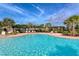 Community pool area with lounge chairs, a pergola, and mature landscaping at 15008 Trinity Fall Way, Bradenton, FL 34212