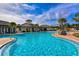 Large community pool with sun loungers, covered seating, and lush landscaping at 15008 Trinity Fall Way, Bradenton, FL 34212