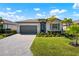 Charming one-story home with a well-manicured lawn, stone driveway, and a neatly landscaped garden at 15937 Honey Suckle St, Port Charlotte, FL 33953