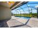 Enclosed pool featuring a screen enclosure, brick pavers, and views of the landscaping at 15937 Honey Suckle St, Port Charlotte, FL 33953