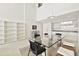 Bright dining area and glass table with eat-in kitchen area in background and modern shelving at 1990 Main St # 10, Sarasota, FL 34236