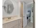 Bathroom with a large round mirror, sink, and view into another room at 2350 N Beach Rd # 1A, Englewood, FL 34223