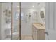 Bright bathroom featuring a glass shower, white vanity, and decorative towel storage at 2350 N Beach Rd # 1A, Englewood, FL 34223