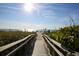 Picturesque boardwalk leading to a beautiful beach with clear skies and glistening ocean views at 2350 N Beach Rd # 1A, Englewood, FL 34223