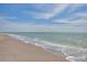 Scenic view of the beach featuring a serene shoreline meeting the tranquil ocean under a partly cloudy sky at 2350 N Beach Rd # 1A, Englewood, FL 34223