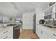 Open kitchen and living area with stainless steel refrigerator, white cabinets, and view to the open living area at 2350 N Beach Rd # 1A, Englewood, FL 34223