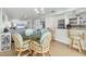 Open-concept living and dining area with bar seating, a glass table, and view to the kitchen at 2350 N Beach Rd # 1A, Englewood, FL 34223