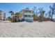 Two-story beach house with balconies surrounded by sand and vegetation at 2350 N Beach Rd # 1B, Englewood, FL 34223