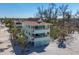 Beach house exterior featuring multi-level balconies, palm trees, and access to a sandy beach at 2350 N Beach Rd # 1B, Englewood, FL 34223