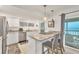 Modern kitchen with marble countertop island, stainless steel appliances, and ocean view at 2350 N Beach Rd # 1B, Englewood, FL 34223