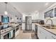 Bright kitchen with stainless steel appliances, white cabinets, and open layout to the living area at 2350 N Beach Rd # 1B, Englewood, FL 34223