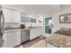 Well-lit kitchen with stainless steel appliances, bright white cabinets, and modern finishes at 2350 N Beach Rd # 1B, Englewood, FL 34223