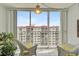 Balcony featuring two white chairs, a table, tile flooring, and a large picture window offering great natural light at 244 Saint Augustine Ave # 905, Venice, FL 34285
