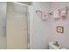 Bathroom features a glass shower, pink wallpaper with floral pattern, and a small floral picture on the wall at 244 Saint Augustine Ave # 905, Venice, FL 34285
