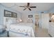 Inviting bedroom with ceiling fan, two paintings on the wall above the bed, and ensuite bathroom at 244 Saint Augustine Ave # 905, Venice, FL 34285
