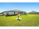 This home features a large backyard area with green grass and a small palm tree at 25259 Alcazar Dr, Punta Gorda, FL 33955