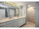 Bathroom featuring double sinks, white cabinets, walk-in shower, and modern lighting at 25259 Alcazar Dr, Punta Gorda, FL 33955