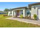 Charming single-story home featuring a red front door, well-manicured landscaping, and a paved walkway at 25259 Alcazar Dr, Punta Gorda, FL 33955