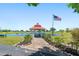 Gazebo with red roof by the pond and an American flag on a clear day at 25259 Alcazar Dr, Punta Gorda, FL 33955