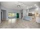 Bright and airy living room with tile floors, a sliding glass door to the patio, and an open kitchen area at 25259 Alcazar Dr, Punta Gorda, FL 33955