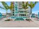 Condo pool area with a hot tub, palm trees, umbrellas, and cushioned seating at 301 Quay Cmn # 1005, Sarasota, FL 34236