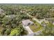 Aerial view of home with manicured lawn, mature landscaping, and long driveway in a lush, green neighborhood at 3189 Seattle Ave, North Port, FL 34286