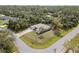 Aerial view of home with green lawn, mature palm tree, and a long driveway, surrounded by lush greenery at 3189 Seattle Ave, North Port, FL 34286