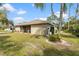 Backyard of home showing screened lanai, mature trees and landscaping and outdoor utility area at 3189 Seattle Ave, North Port, FL 34286