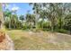 A sprawling backyard featuring lush greenery, mature trees, and comfortable outdoor seating at 3189 Seattle Ave, North Port, FL 34286