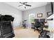 This bedroom has carpet floors, a ceiling fan, a window, a desk, and workout equipment at 3189 Seattle Ave, North Port, FL 34286