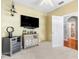 This bedroom has carpet floors, light yellow walls, a TV, and a drink cabinet at 3189 Seattle Ave, North Port, FL 34286