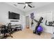 This bedroom has carpet floors, a ceiling fan, a TV, a desk, and workout equipment at 3189 Seattle Ave, North Port, FL 34286